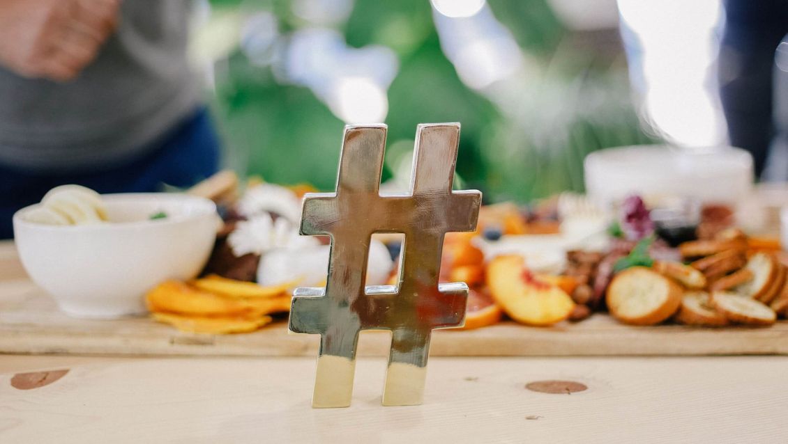 Bilde av en hashtag på et bord med mat i bakgrunnen